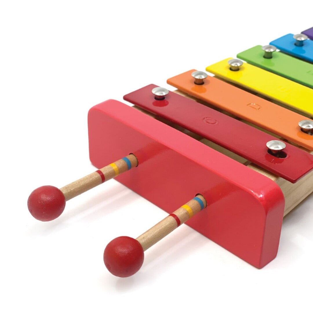 Detail van de regenboog xylofoon met twee rode mallets opgeborgen in de houten zijkant.