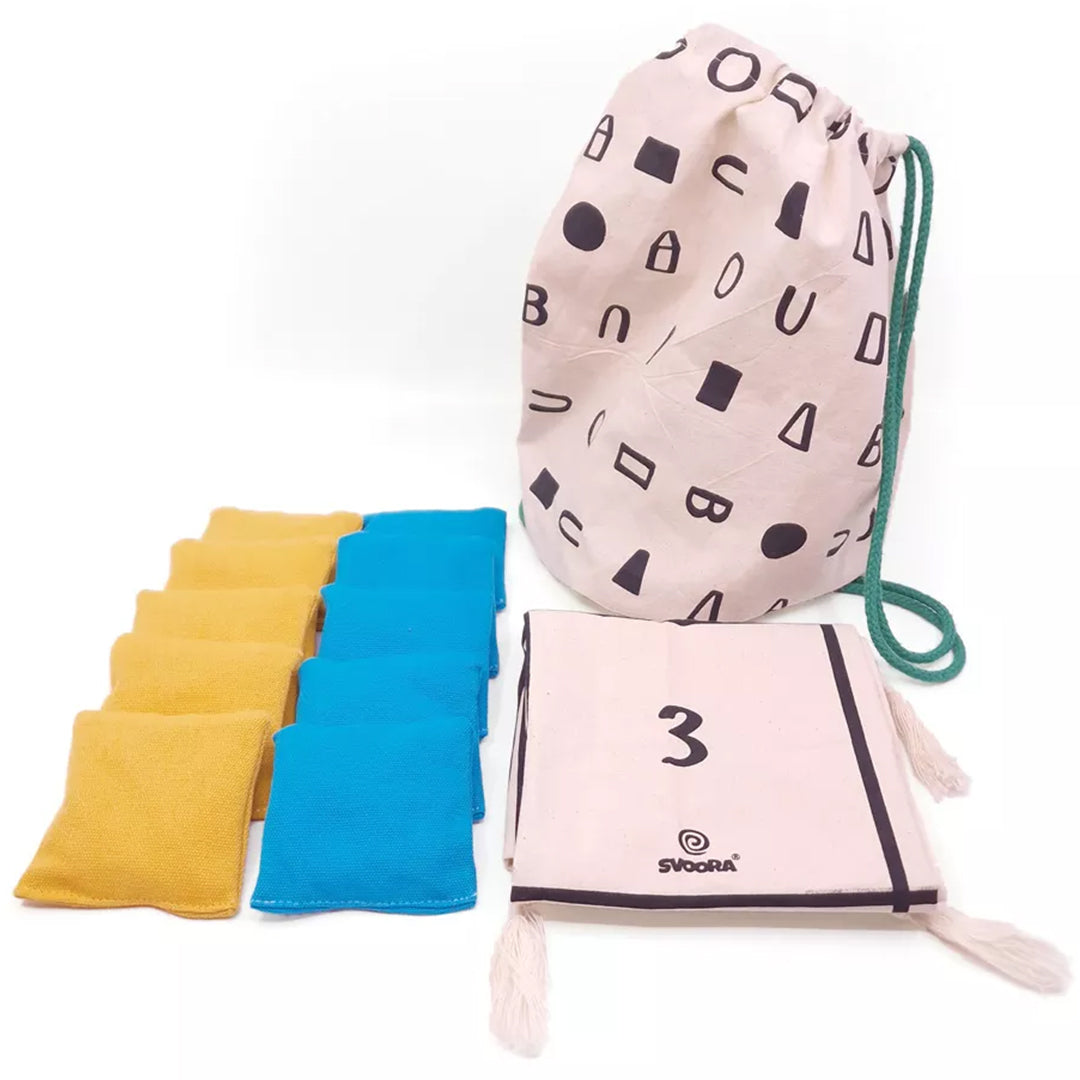 Een Svoora gooispel set met gele en blauwe bonenzakken, een opbergzak en een opgevouwen speelmat.