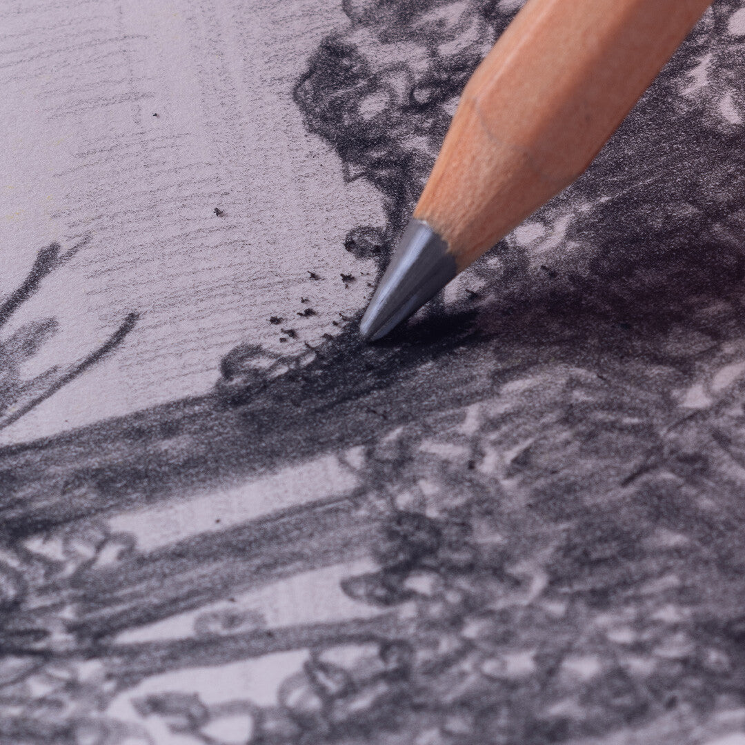Een Talens Art Creation grafietpotlood tekent fijne details op papier, met grafietresten zichtbaar.