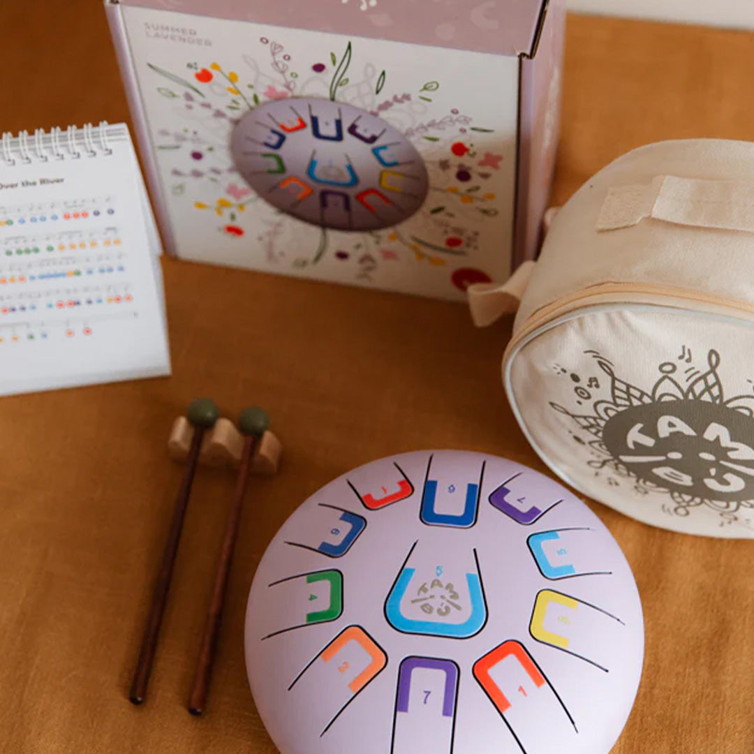 De tambu tongtrommel met verpakking, draagtas, mallets en muziekboek.