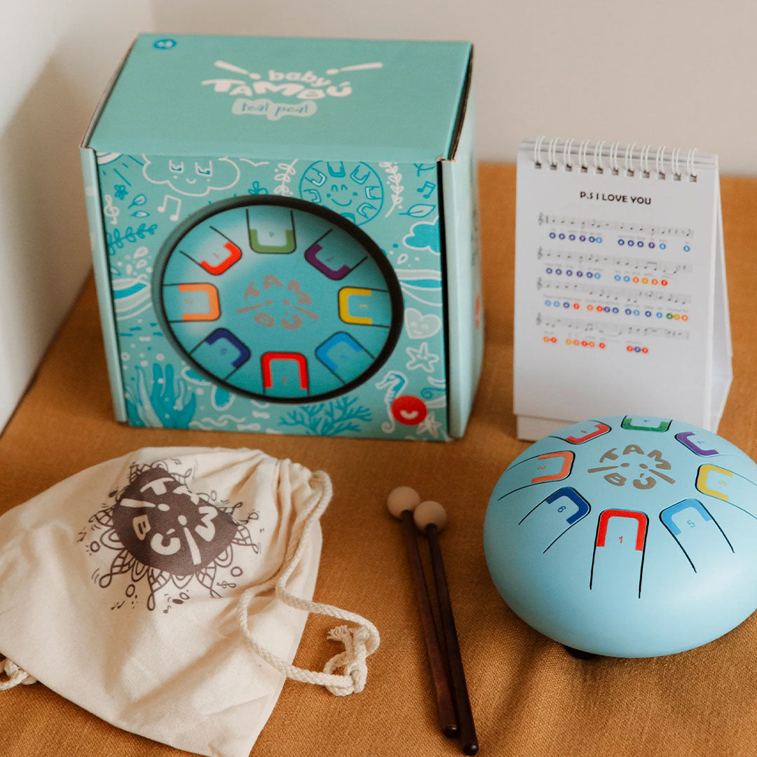 De tambu tongtrommel set met verpakking, draagtas, stokjes en muziekboekje.