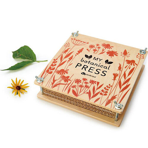 Gesloten Tender Leaf Toys houten bloemenpers met botanische illustraties, een gele bloem en een groen blad ernaast.