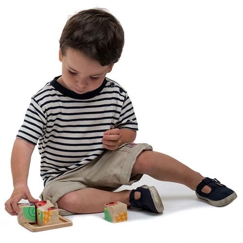 Een jongetje speelt op de grond met de Tender Leaf Toys houten blokkenpuzzel.