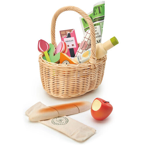 Tender Leaf Toys speelgoed boodschappenmandje met houten etenswaren zoals een baguette en een appel ernaast.