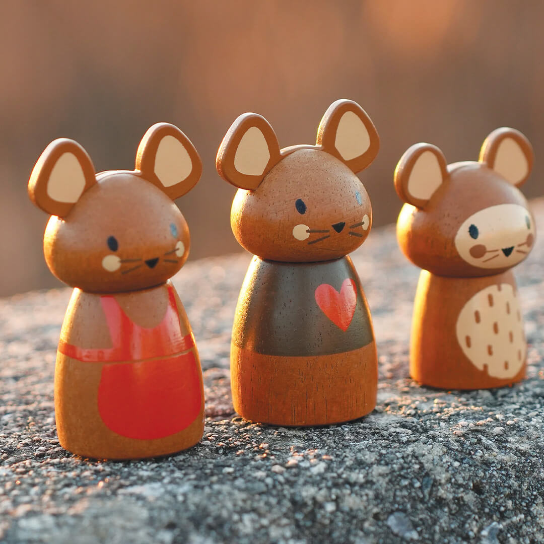 Close-up van drie houten muizenfiguren van de Tender Leaf Toys speelset op een stenen ondergrond.