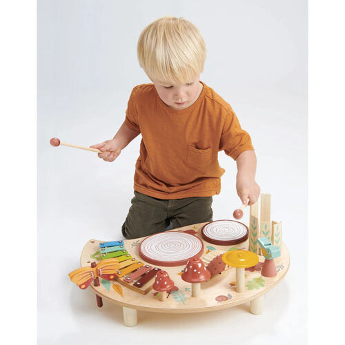 Een jongen speelt met de Tender Leaf Toys houten muziekspeelgoedtafel met bosdieren.