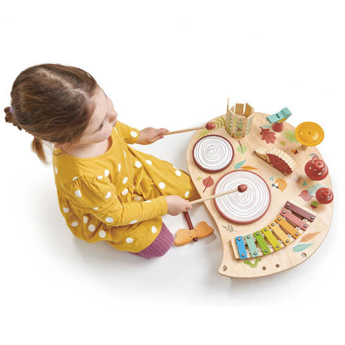 Een meisje speelt van bovenaf gezien op de drums van de Tender Leaf Toys houten muziekspeelgoedtafel met bosdieren.