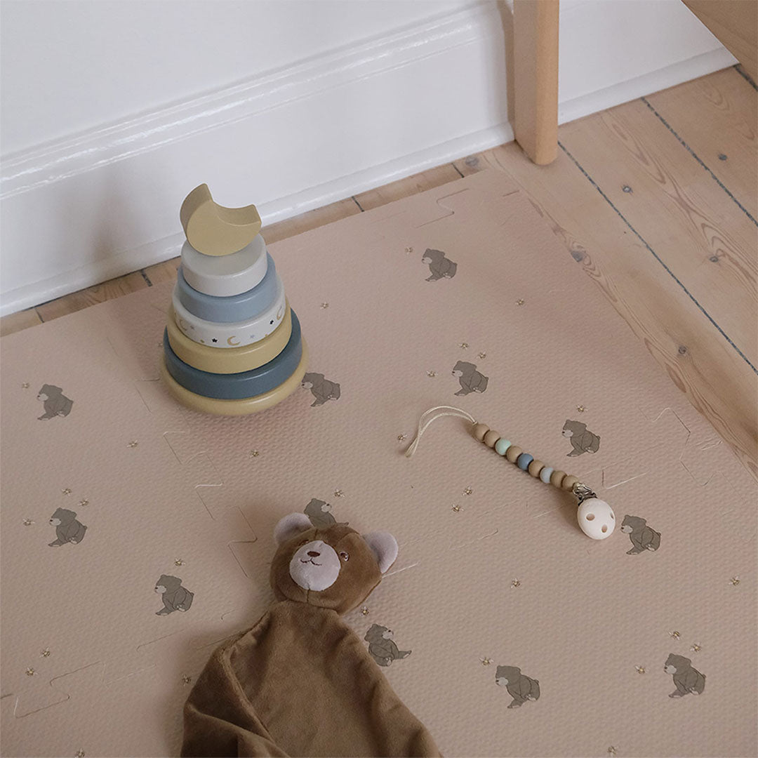 Detail van de that's mine roze foam speelmat met beren en bijen patroon, met babyspeelgoed.