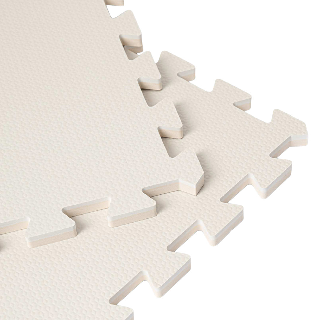 Detail van de in elkaar grijpende randen en textuur van de pastelgrijze foam speelmat.