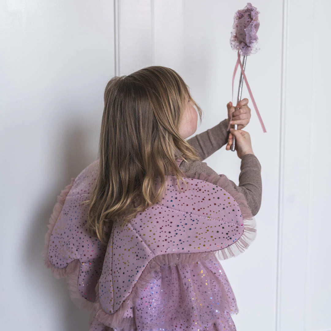 Kind van achteren met roze vlindervleugels en toverstaf met sterrenpatroon.