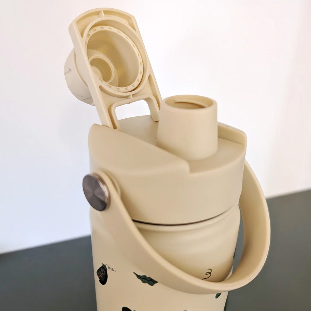 Detail van de open beige the cotton cloud dop zonder rietje op een drinkfles.