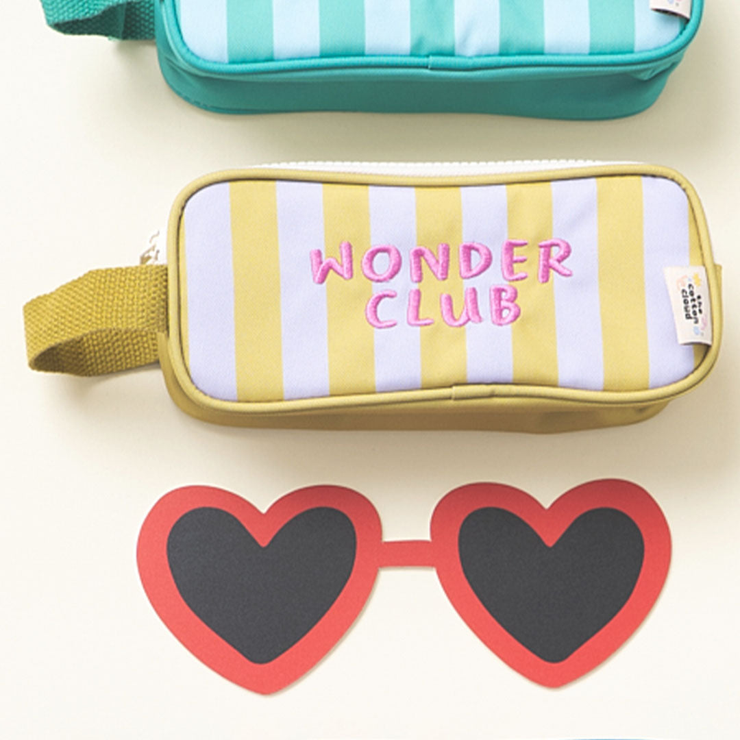 De the cotton cloud etui met gele en lichtpaarse strepen, liggend tussen een andere etui en een rode hartjesbril.