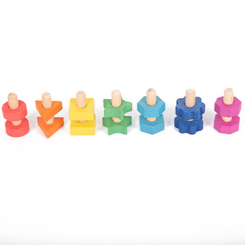 Zeven paren van tickit houten bouten en moeren speelgoed in regenboogkleuren, in elkaar geschroefd en op een rij.