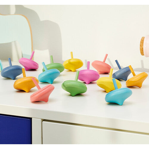 tickit houten draaitolletjes in regenboogkleuren op een witte plank in een kinderkamer.