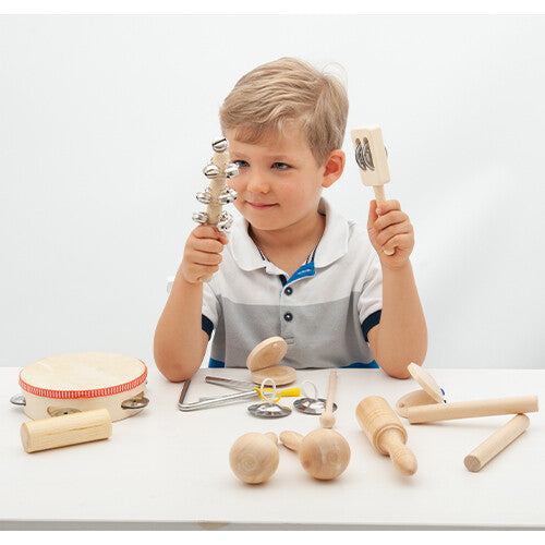 Een jongen speelt met een metalen shaker en een houten rammelaar uit de tickit muziekinstrumenten set.