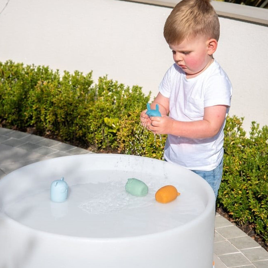 Een jongen speelt met de tickit silisoft dieren waterspuiters in een watertafel.