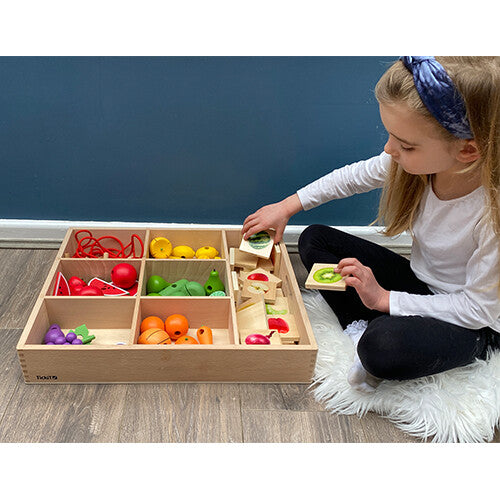 Kind speelt met de Tickit houten sorteerbak gevuld met houten fruit en groenten, en bijpassende kaarten.