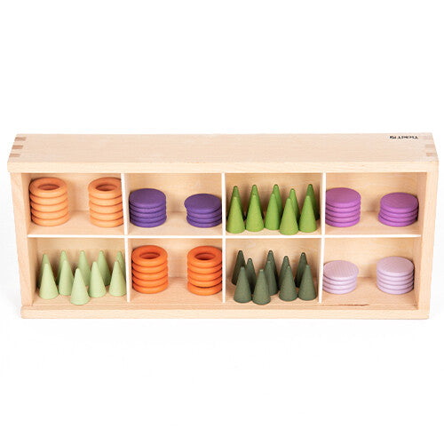 Een houten Tickit sorteerbak met tien vakken, gevuld met oranje en paarse ringen en groene houten kegels.