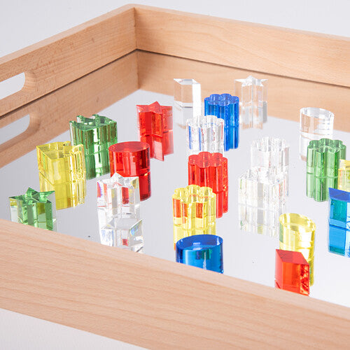 TickiT houten speelbak met spiegel gevuld met kleurrijke, transparante acryl vormen.