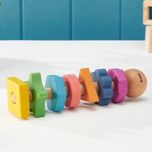tickit houten vormen twister met regenboogkleurige geometrische vormen op een witte tafel.