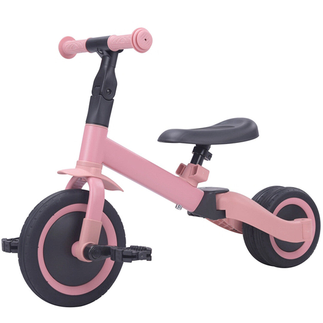 Topmark 4-in-1 roze driewieler met pedalen en een breed achterwiel, schuin van voren gefotografeerd.