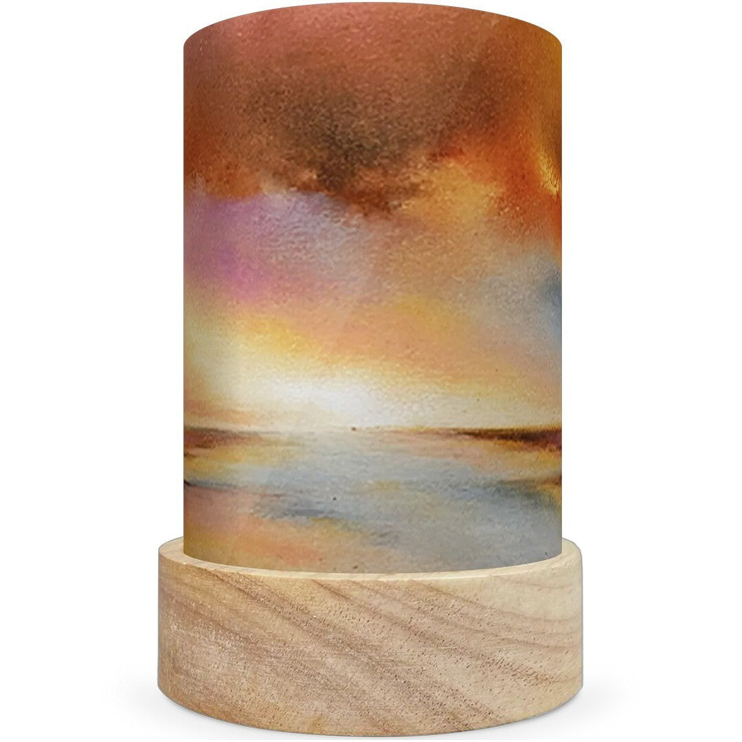 Een toverlux lichtkaart met een illustratie van een zonsondergang boven water op een houten voetje.