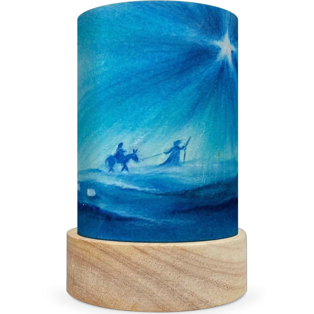 Een toverlux lichtkaart met een kerstillustratie van figuren met een ezel onder een heldere ster op een houten voetje.