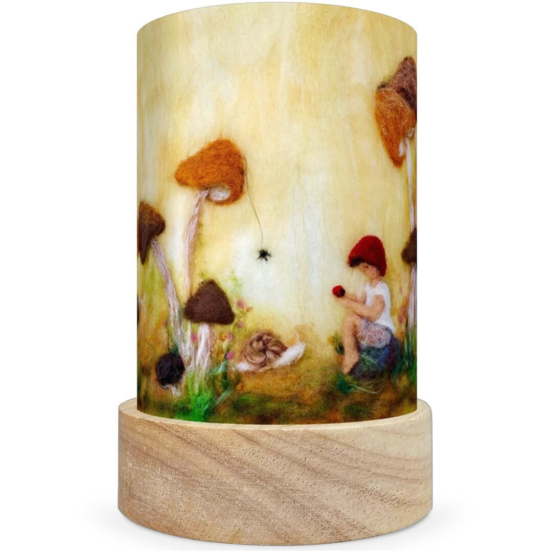 Een Toverlux lichtkaart met een kindje met een rode muts dat tussen paddenstoelen en een spin zit.