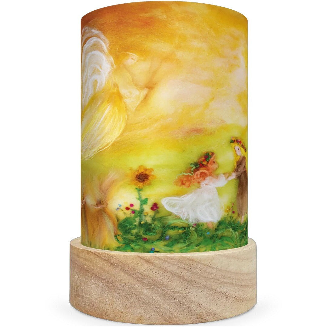 Een Toverlux lichtkaart voor een lantaarn met een afbeelding van figuren in een zonnig bloemenveld met een engel, in een droomwereldthema.
