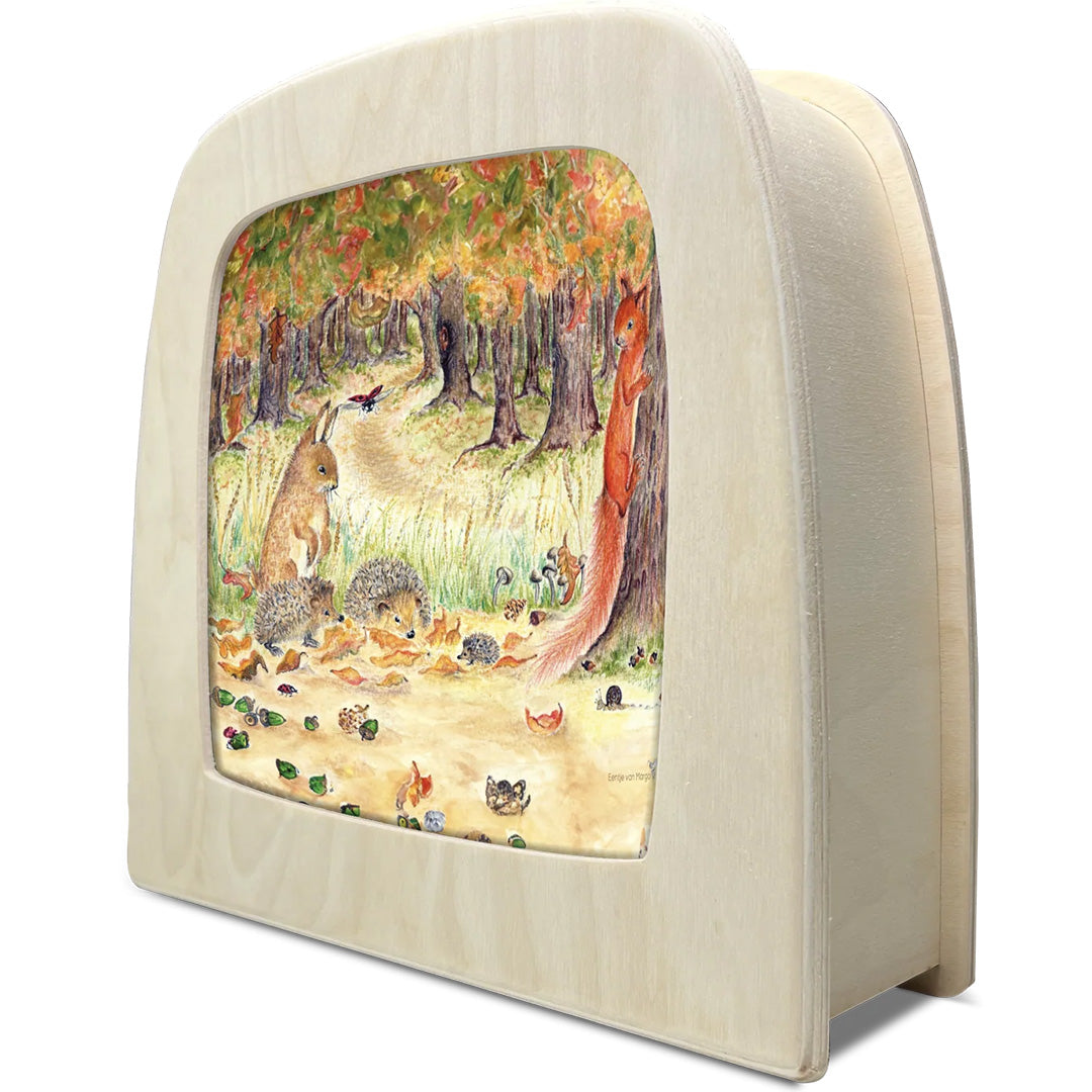 Schuine weergave van een Toverlux toverlamp met de herfstbos illustratie.