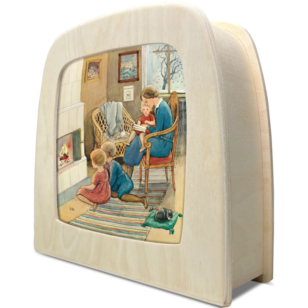 Schuine weergave van een Toverlux toverlamp met de toverplaat van een moeder die voorleest aan kinderen bij de open haard.