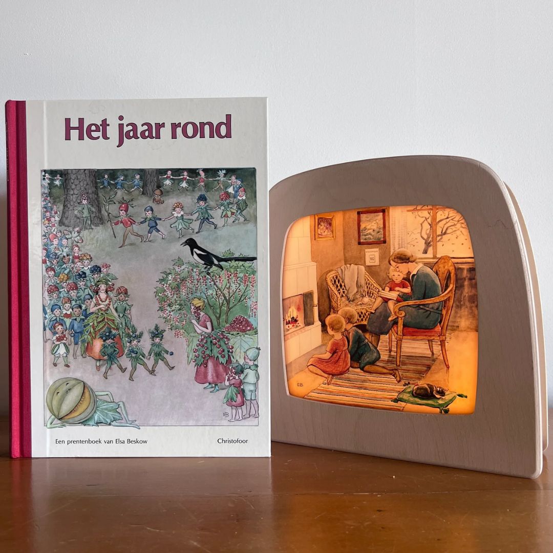 Toverlux toverlamp met de november toverplaat naast het boek 'Het jaar rond' van Elsa Beskow.