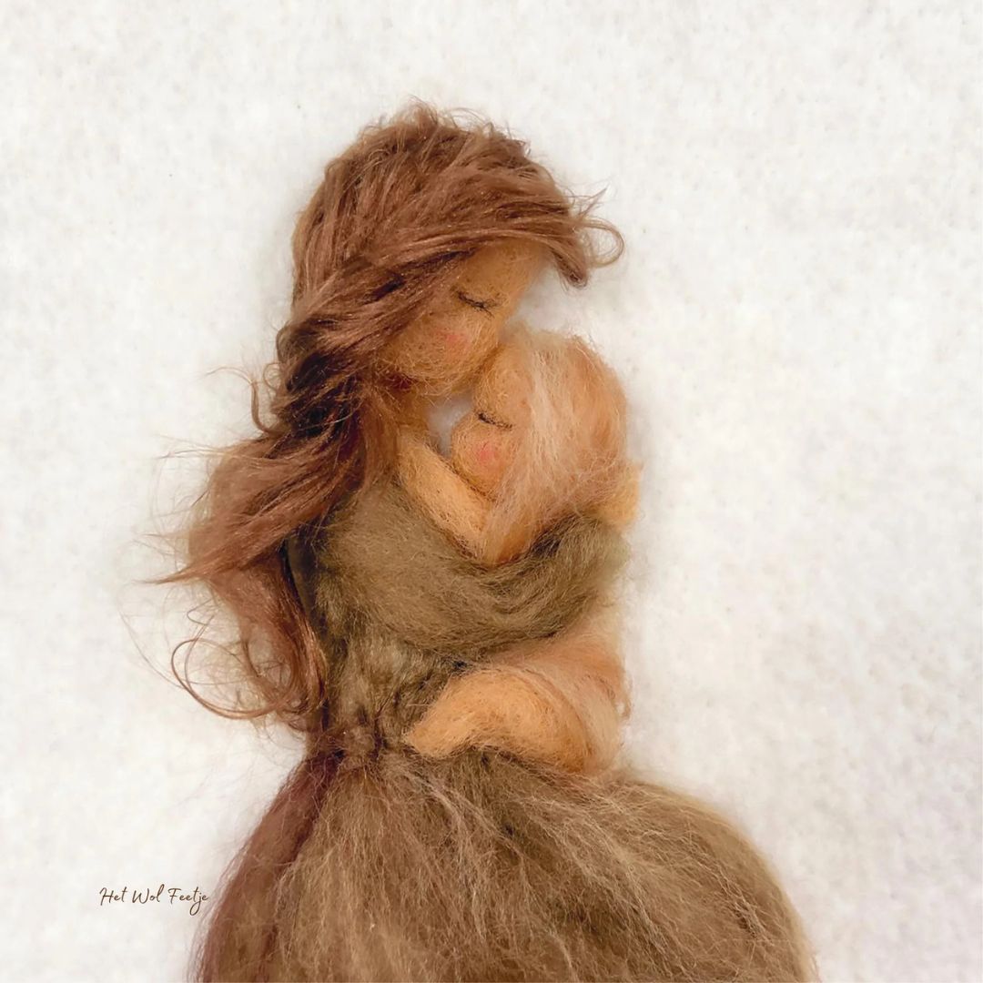 Toverlux toverplaat met een kunstwerk van wolvilt dat een moeder met baby omhelzend afbeeldt.
