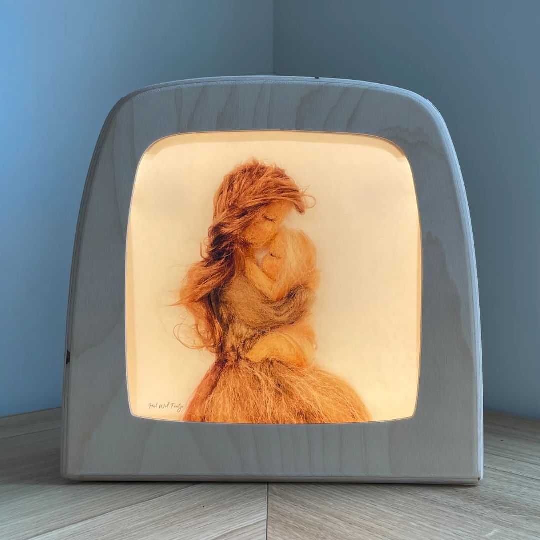 Toverlux toverlamp met de verlichte toverplaat van een moeder en baby, gezien van voren.