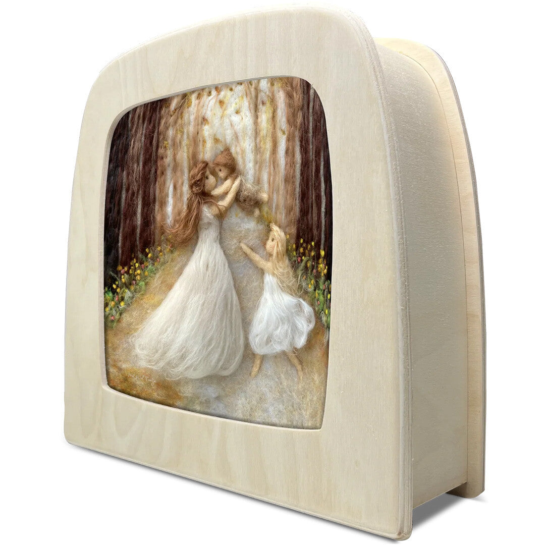 Een schuine weergave van de Toverlux toverlamp met de toverplaat 'moeder met kinderen' in een houten frame.