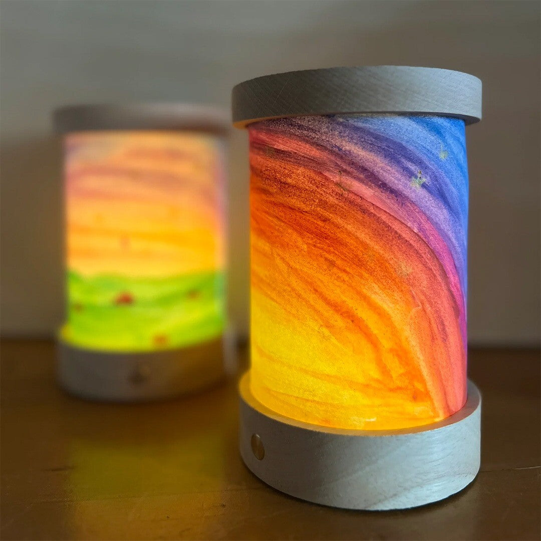 Toverlux lantaarns, de voorste met een regenboogpatroon en de achterste met een landschap.