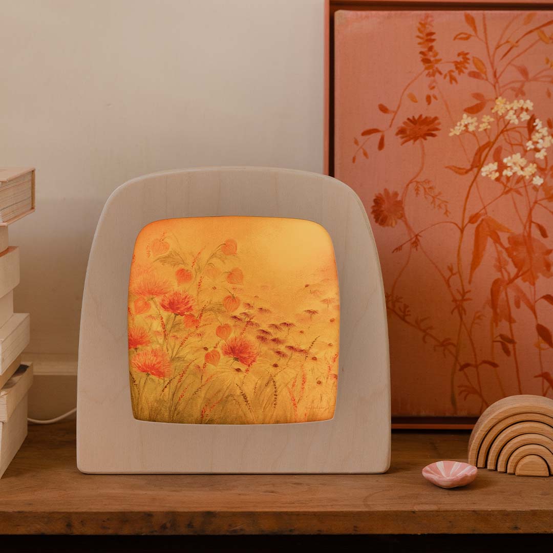 Toverlux toverplaat met gebloemd patroon in een houten frame, staand op een houten plank.