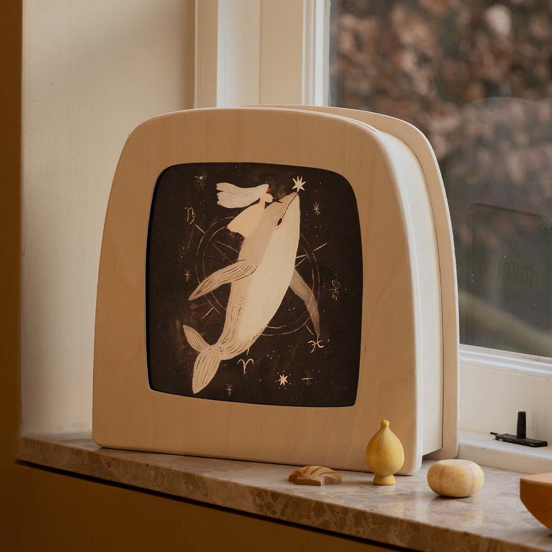 Toverlux toverlamp met de walvis toverplaat, staand op een vensterbank.