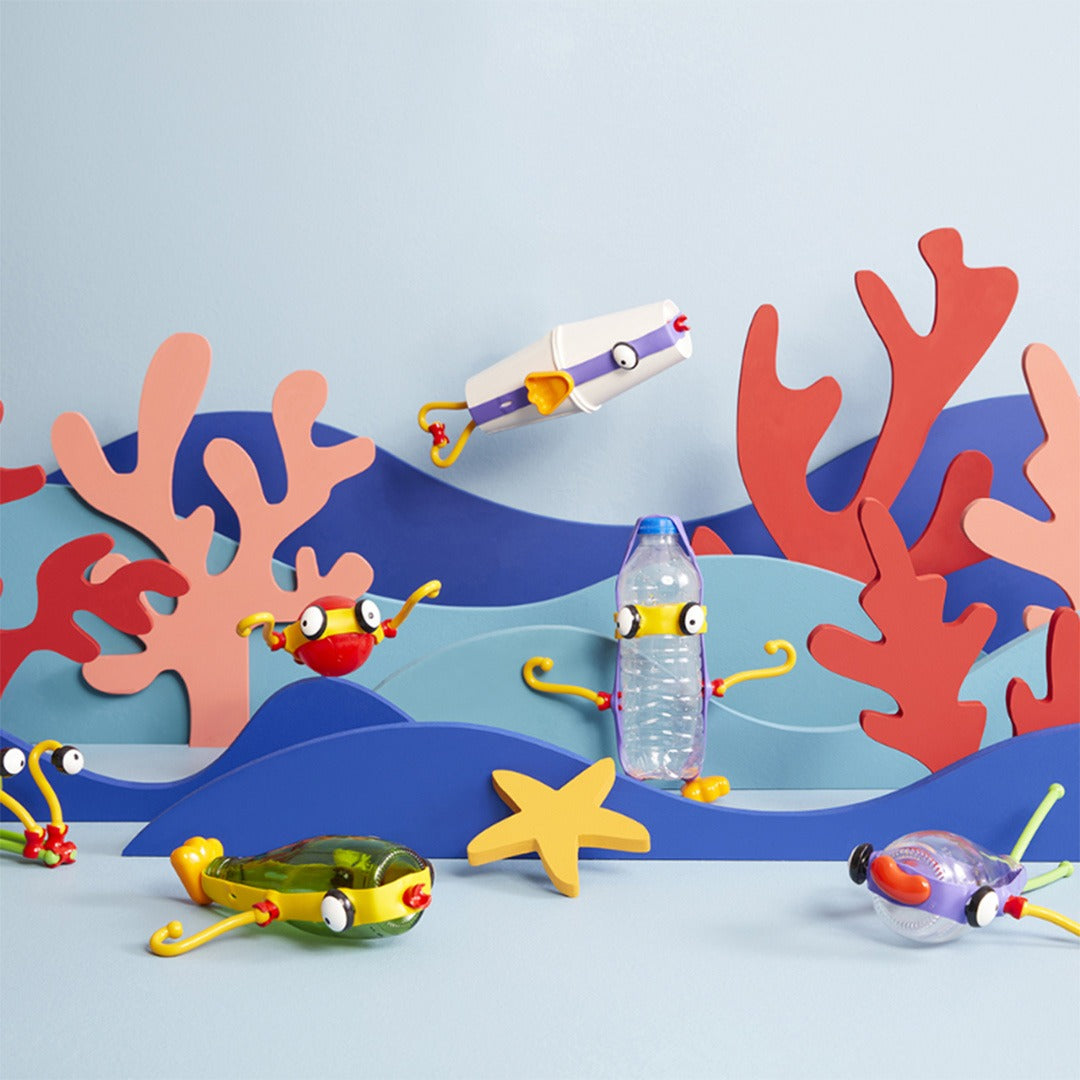 Diverse kleurrijke Toyi figuren gemaakt van flessen en bouwdelen in een onderwaterlandschap.