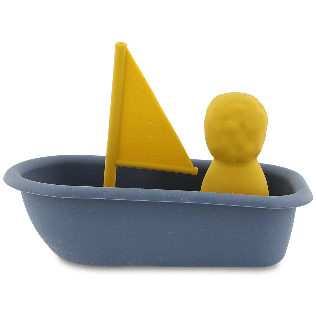 Trixie badspeelgoed zeilboot met een gele figuur en geel zeil, van achteren gezien.