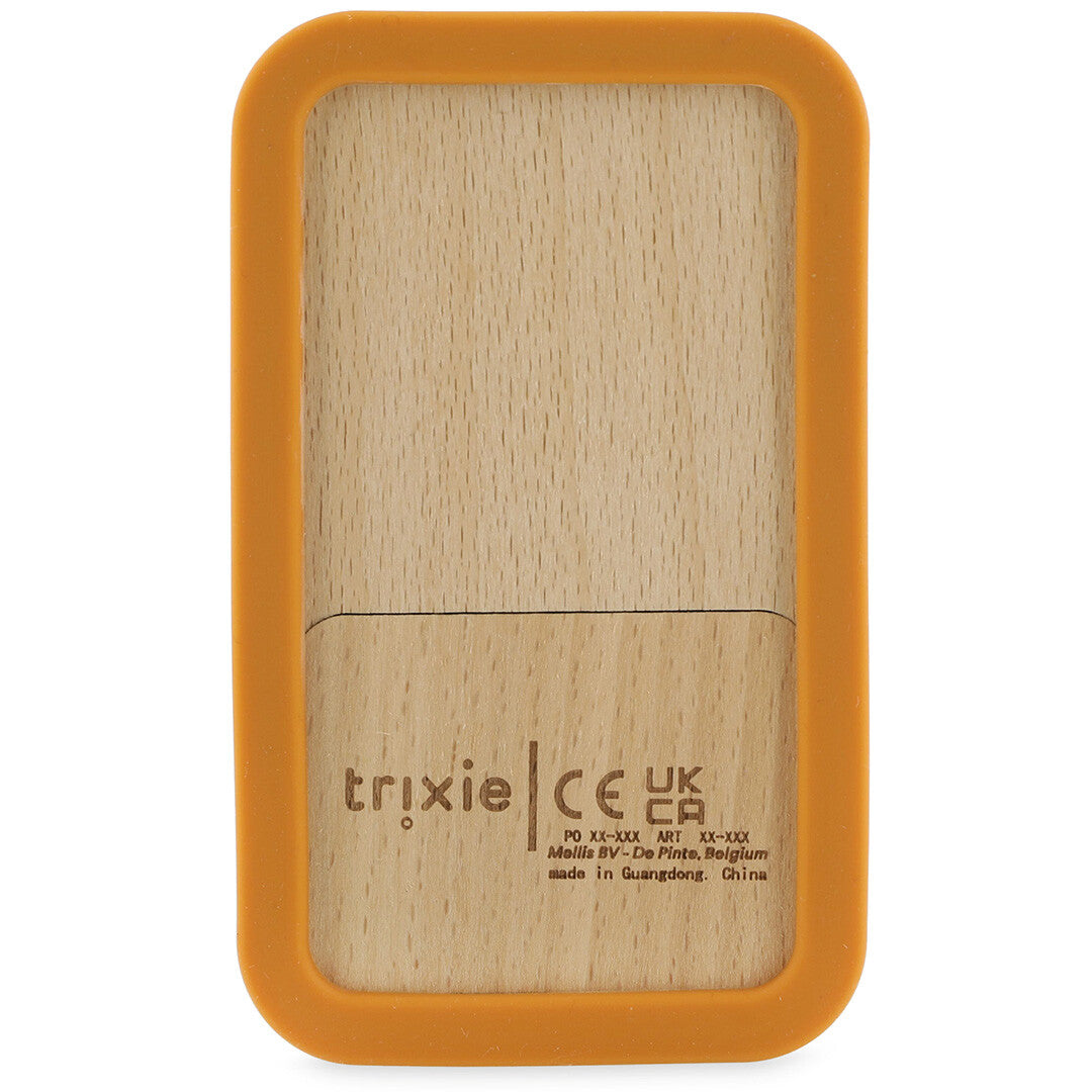 De achterkant van het Trixie bijtspeelgoed telefoon met houten oppervlak en gedrukte productinformatie.