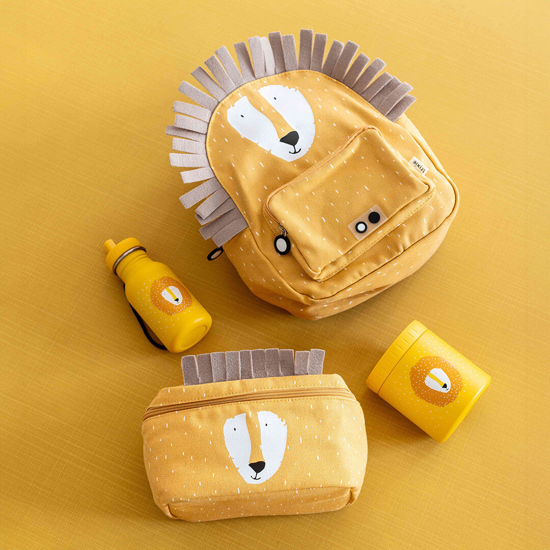 Een collectie Trixie kinderaccessoires met leeuwenthema, waaronder een rugzak, drinkfles, etui en geïsoleerde voedselpot.