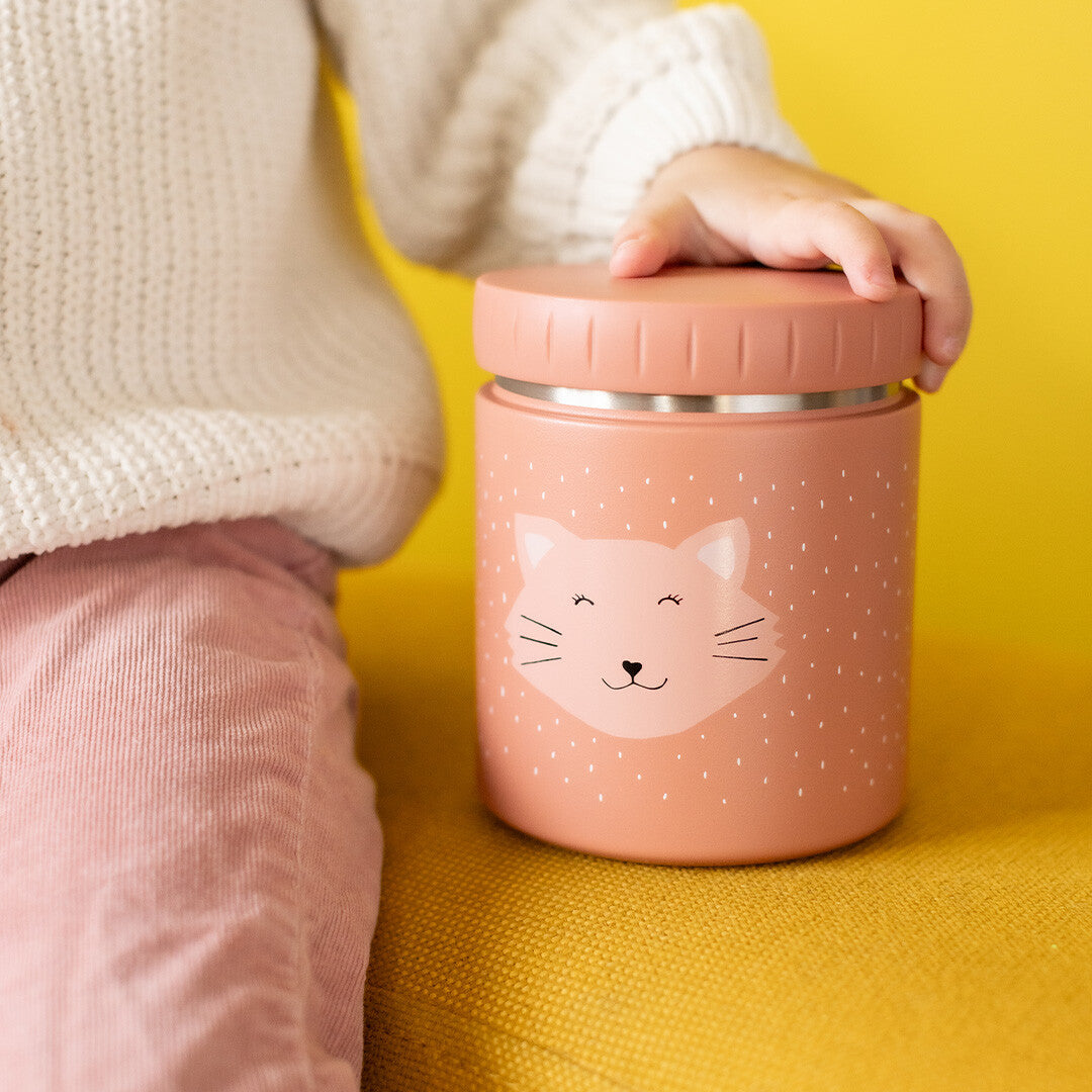 Een kind pakt de Trixie geïsoleerde voedselpot met kattengezicht van een gele ondergrond.