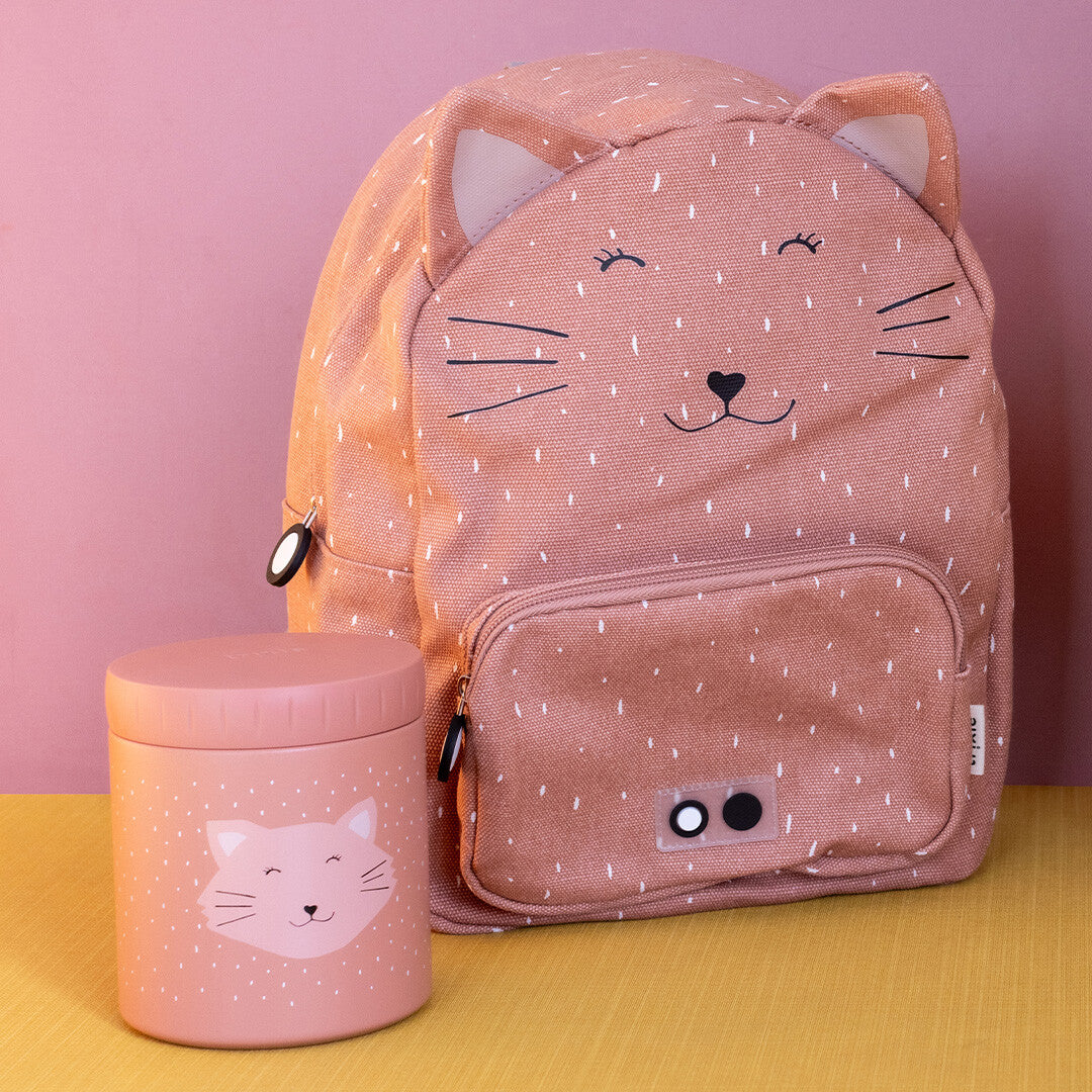 De Trixie geïsoleerde voedselpot met kattengezicht staat naast een bijpassende roze rugzak.