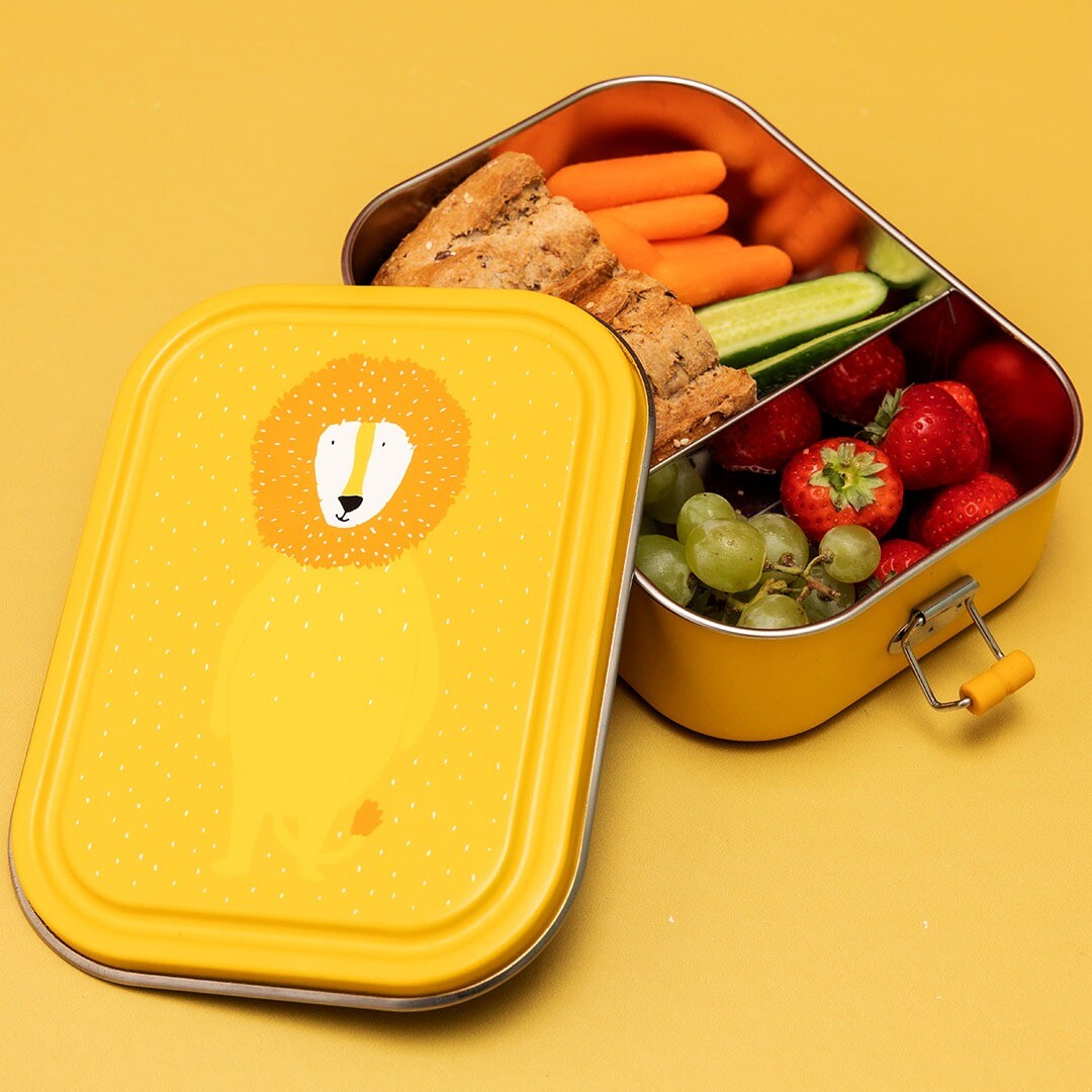 Open Trixie broodtrommel met leeuw illustratie, gevuld met fruit, groenten en brood.