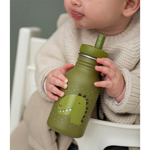 Een baby in een kinderstoel houdt de Trixie groene kinder waterfles met dinosaurus patroon vast.