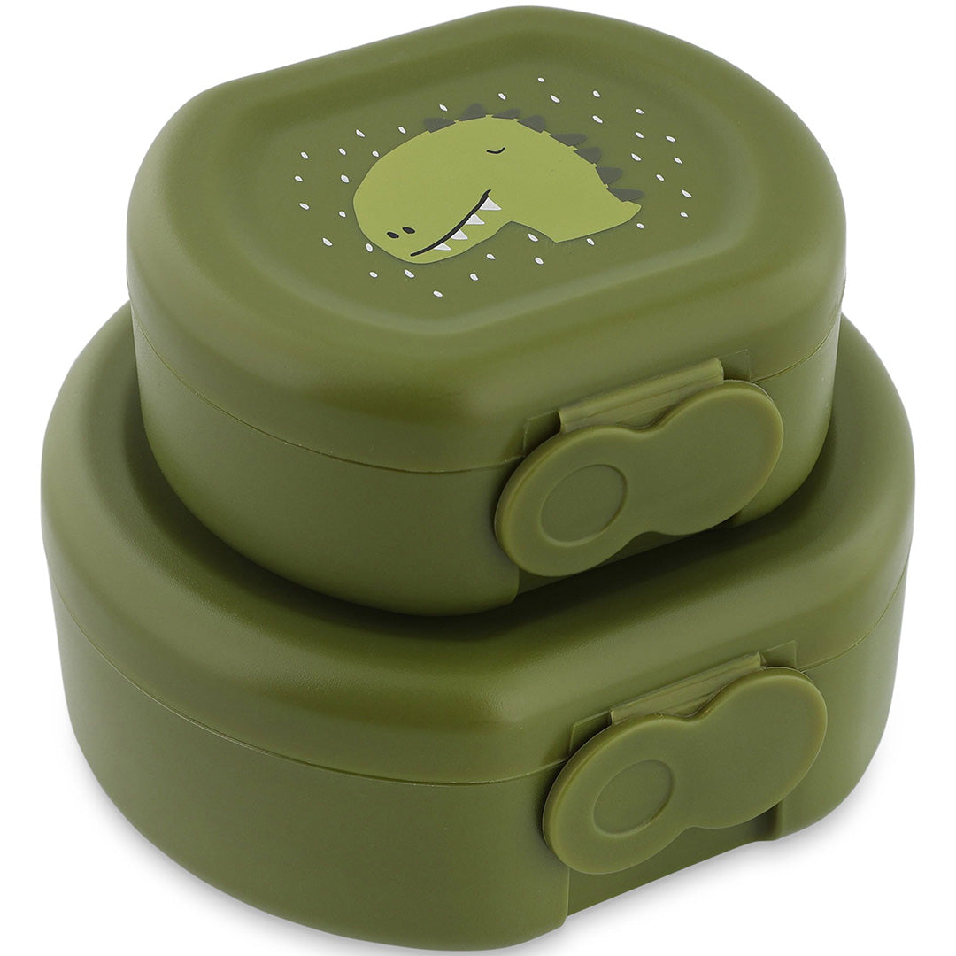 Twee gestapelde groene Trixie snackdoosjes met clips en een dinosaurushoofd op de bovenste.