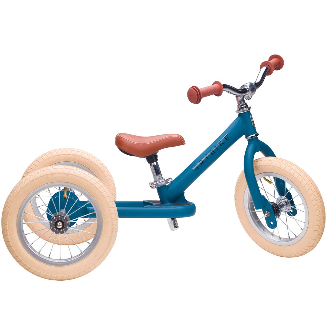 Trybike stalen 2-in-1 loopfiets in vintage blauw als driewieler, schuin van voren gefotografeerd.
