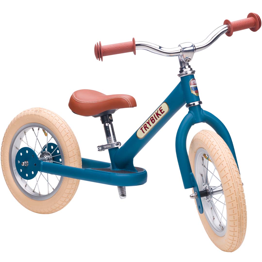Trybike stalen 2-in-1 loopfiets in vintage blauw als tweewieler, schuin van voren gefotografeerd.