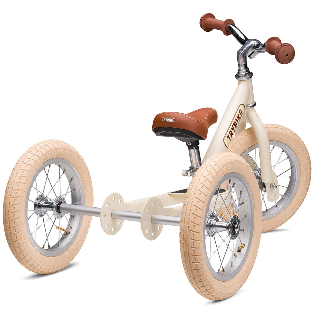 Trybike 2-in-1 loopfiets in vintage cream als driewieler, schuin van achteren gezien.